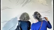 2 femme de dos devant une oeuvre de papier découpé © Jean-Sébastien Faure