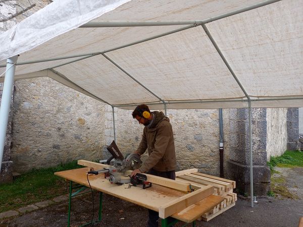 Simon Augade découpe du bois pour l'assemblage de la structure